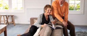 Couple de seniors dans leur salon avec un radiateur a inertie aterno